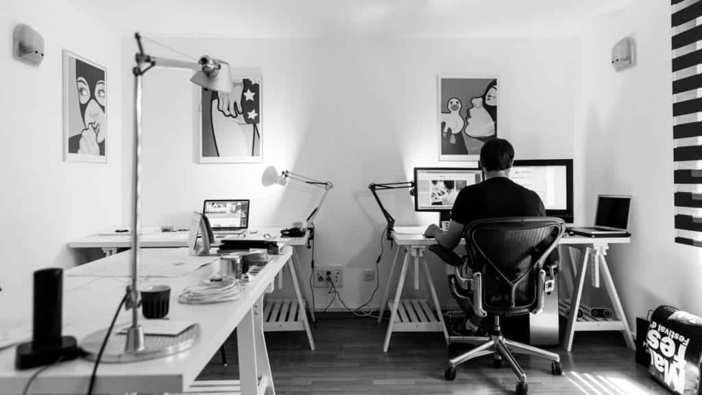 man on computer in white room